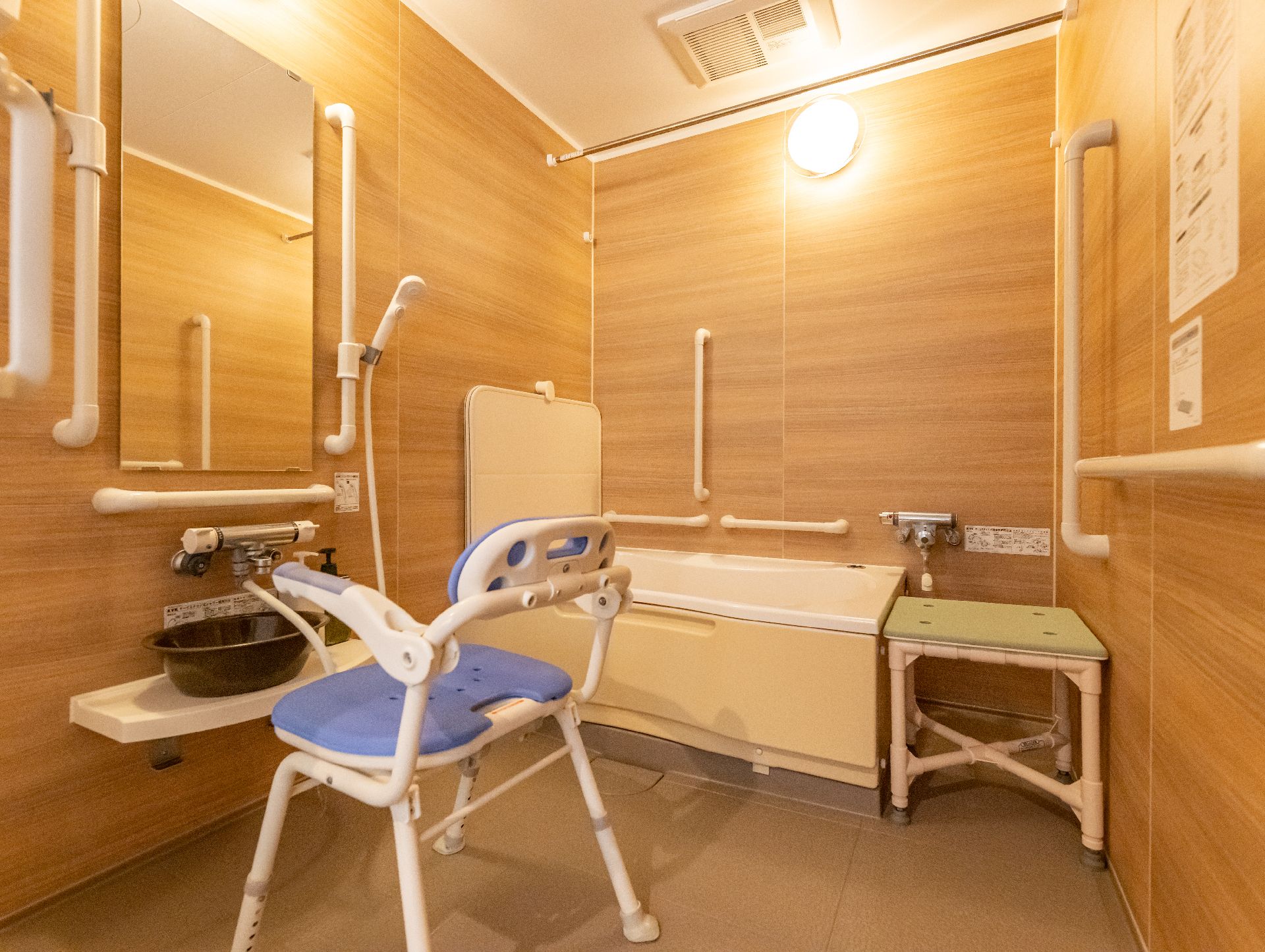手すりが取り付けられ、髪や体が洗いやすいように椅子が置かれた浴室