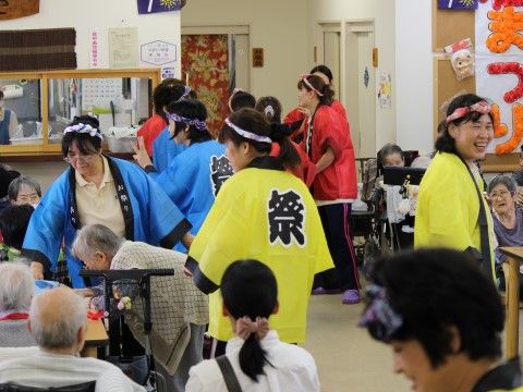 施設内のイベント会場となる食堂で、楽しむ入居者様とはりきるスタッフ