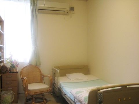 居室内にはベッド、エアコンの他に、椅子や棚などの家具も用意されている。すでに必要なものが揃っている。