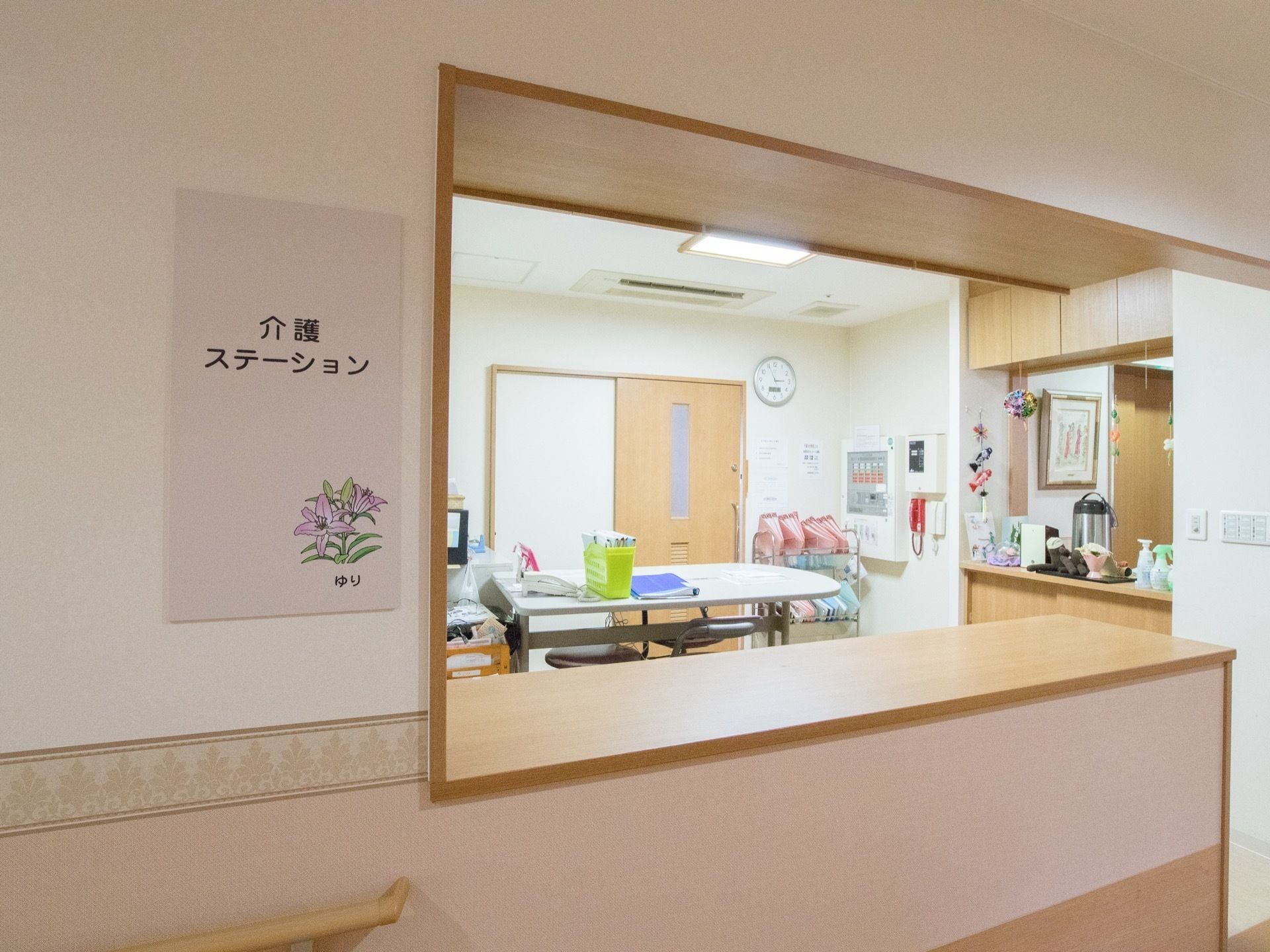 介護ステーションはゆりの花が描かれた看板が大きく貼りだされている。ポットなどの備品が用意されている。