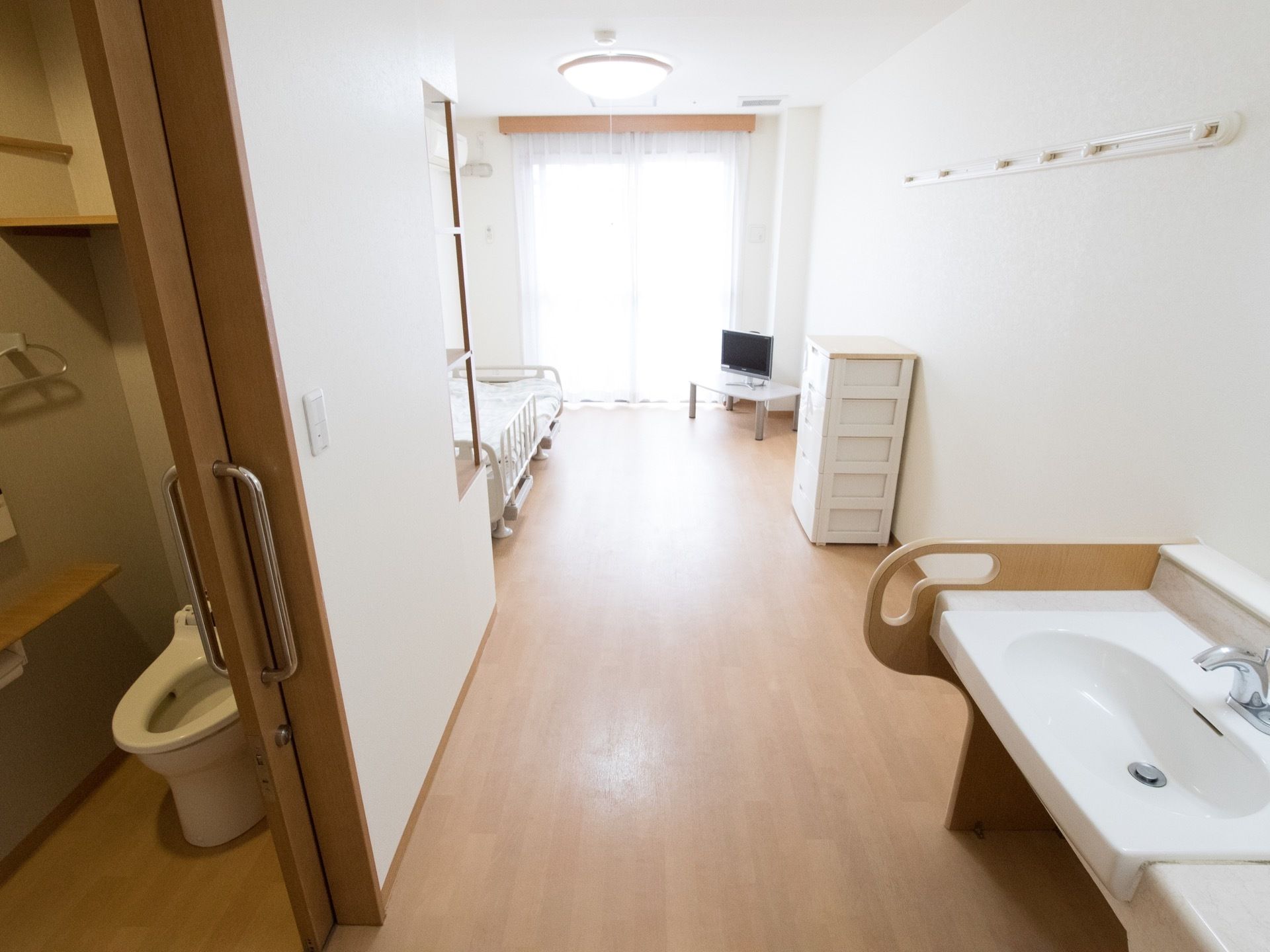 居室にはベッドとテレビ、チェストが備え付けられている。壁には帽子などをかけられるフックが設置されている。