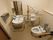 介護度の高い入居者様向けのトイレには、便座に座ったまま手の届く流し台を用意している。手すりを壁だけでなく流し台周囲にも配置している。