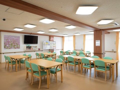 イベントやレクリエーションが行われる、緑の椅子が印象的な明るい雰囲気の多目的室