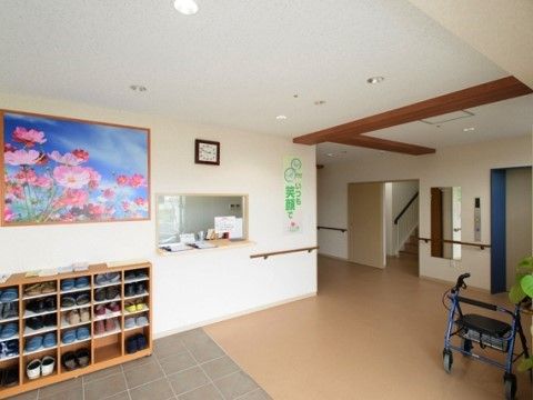 エントランスの出入口の壁には、美しいピンク色をした花びらのコスモスの絵画が飾られており、見る人に癒しを与える。