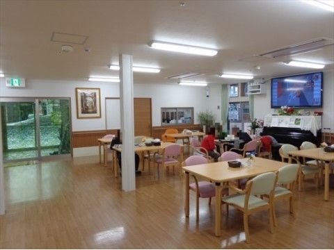 広いフローリングに、机と椅子が置かれている。大きなテレビモニターとピアノが設置されており、隣のスタッフルームから見渡せる窓がある。