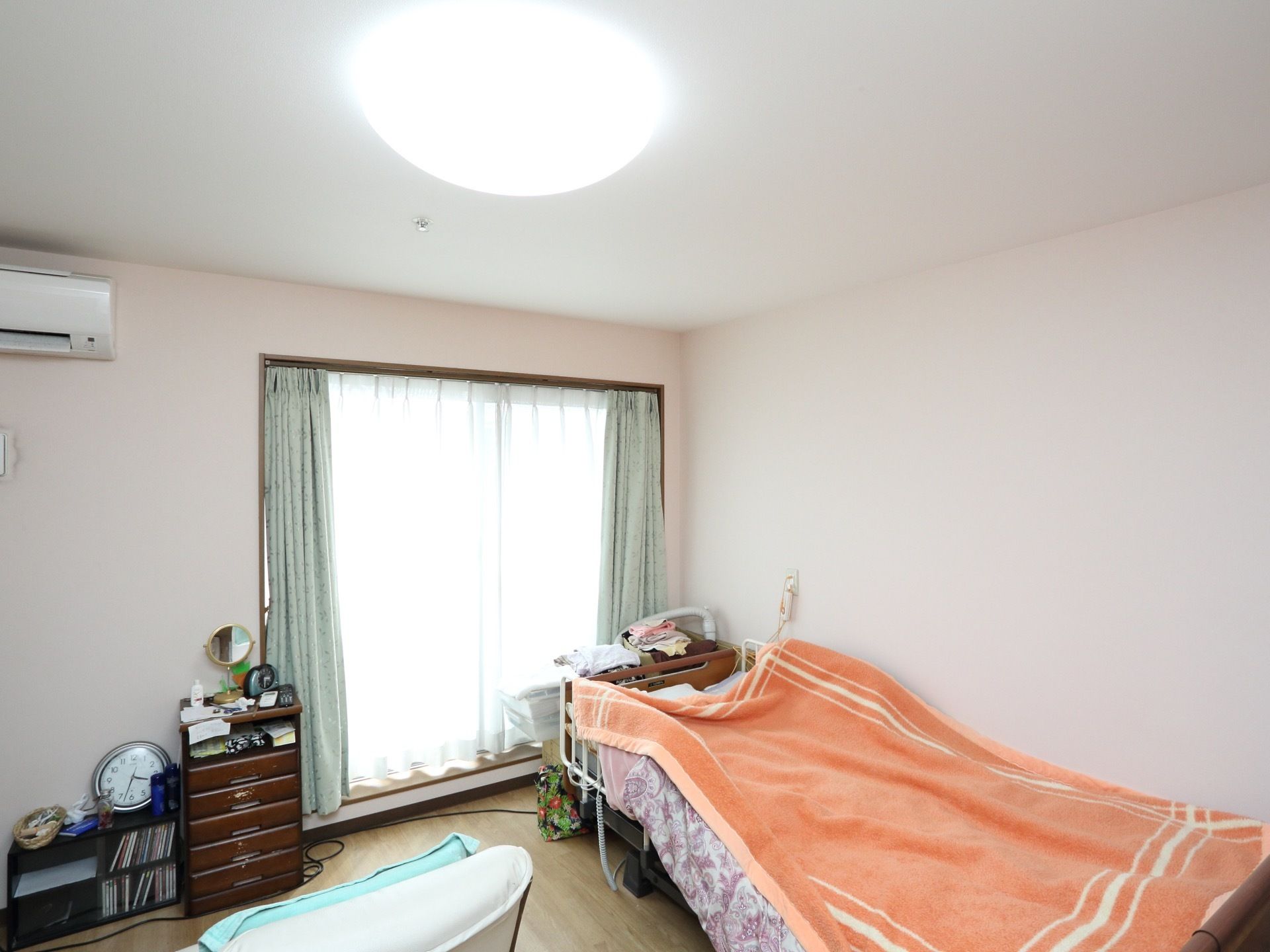 明るい色調に整えられた居室である。掃き出し窓が備えつけられており、陽光が差し込んで明るい。エアコンも完備している。