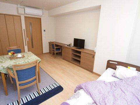 テーブルセットやベッドが設置された居室