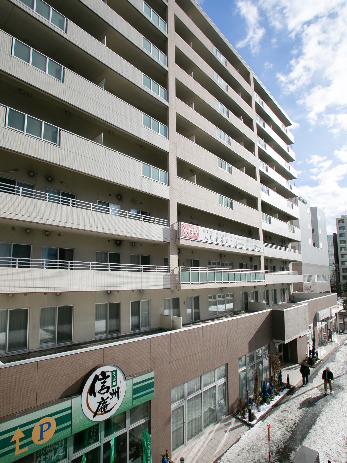 高層マンションのような造りの施設で、１階部分には飲食店などが入居している。２階部分はバルコニーになっている。