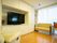壁に作りつけられた棚の一部が大きく開いており、大型液晶テレビが置かれている。テレビの周囲は収納棚になっている。