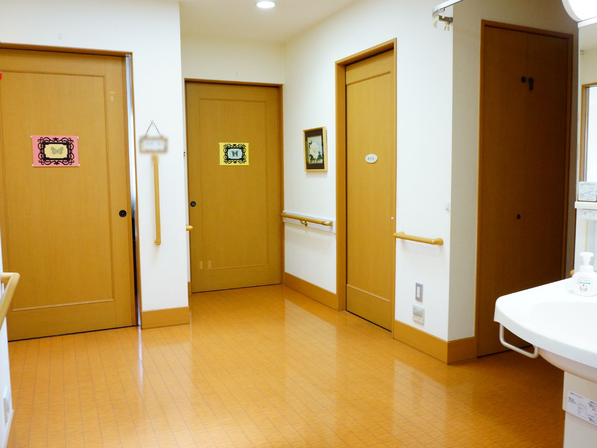 居室を出るとホールがあり、共同で利用する洗面所が設置してある。床はフローリングで、バリアフリーを採用している。