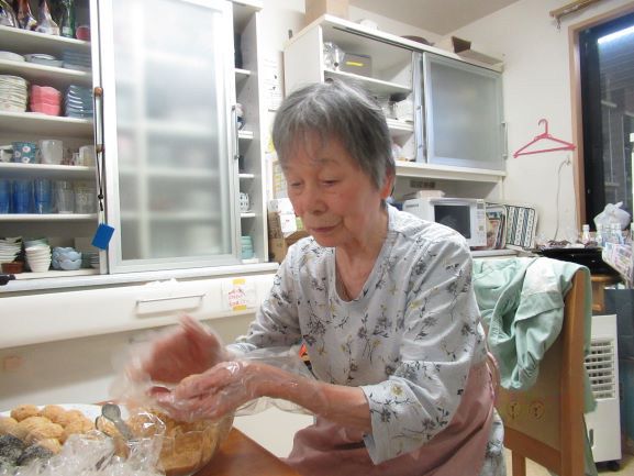 味噌汁をを注いでいる入居者