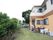 施設にある庭は建物1階から出ることができ、ウッドデッキがある。手前側には芝生、道路沿いには木が植えられている。