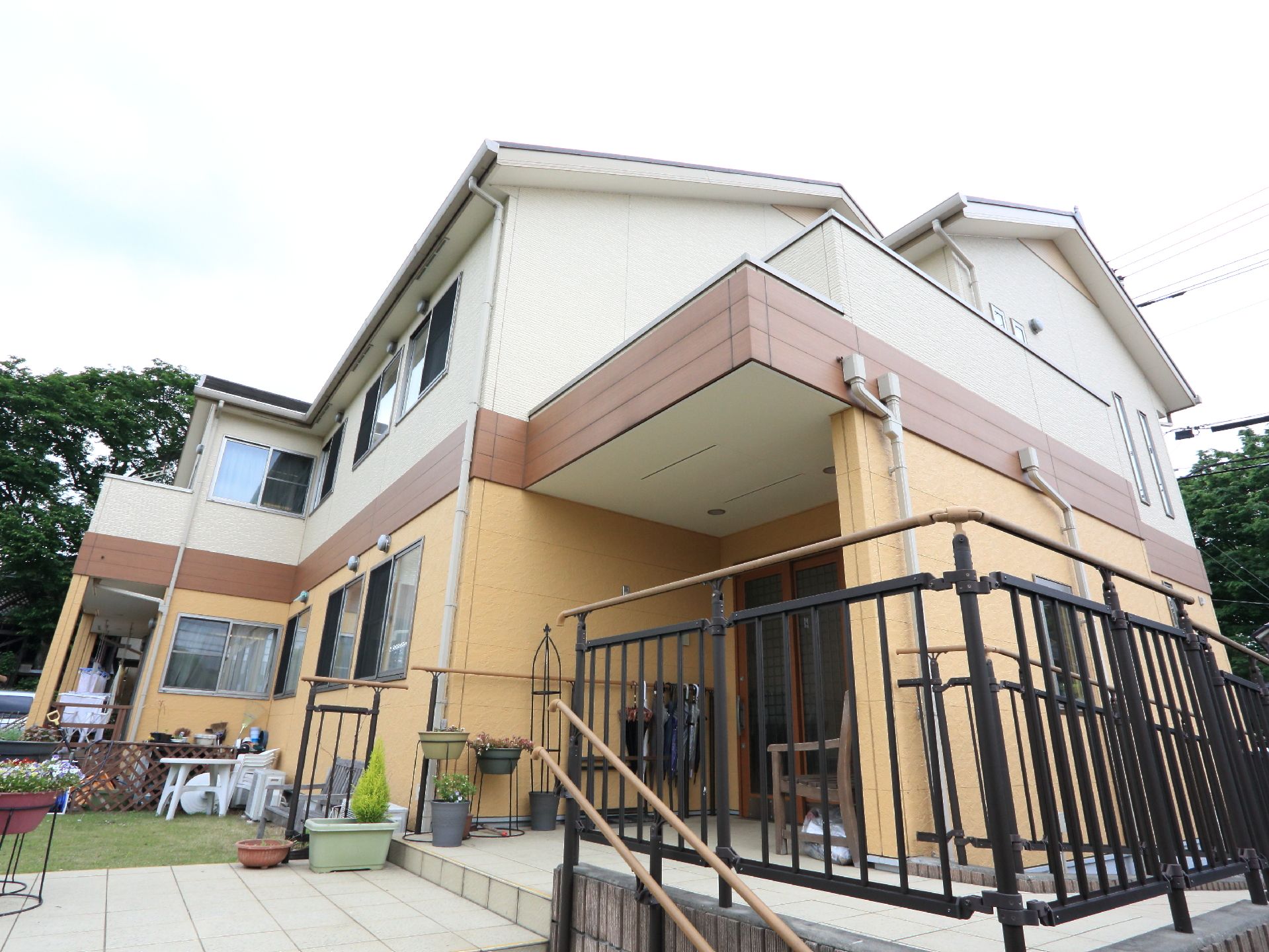 建物へはスロープや高さに配慮された階段がある。玄関の前や芝生にはベンチや花が置かれ、きれいにレイアウトされている。