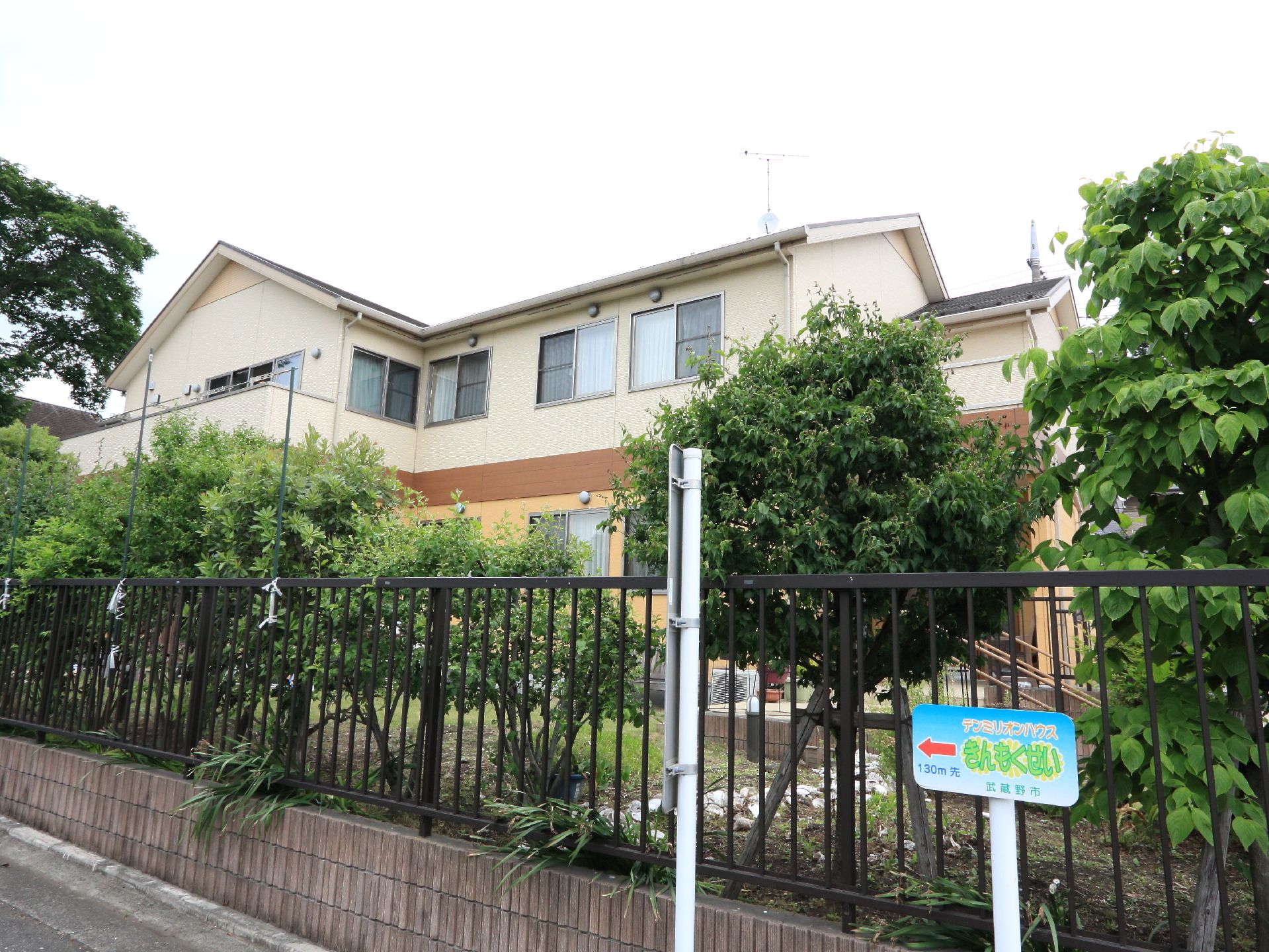 施設の外観はこげ茶色のアルミフェンスで囲われている。道路沿いには木が植えられていて目隠しの代わりをしている。