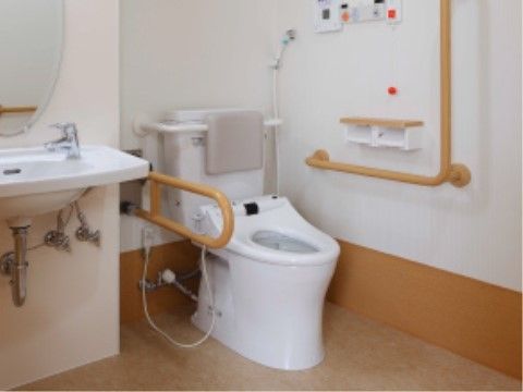 手すり、背もたれのクッションがあり、落ち着いて利用できるトイレである。大きな鏡付きの洗面所も設置されているので、お顔のチェックもできる。