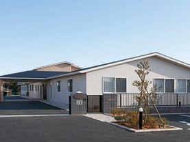 建物は１階建てで、青い三角屋根と白い壁のスッキリした印象の外観である。玄関ポーチは広く、建物周囲にはアスファルトが敷かれている。
