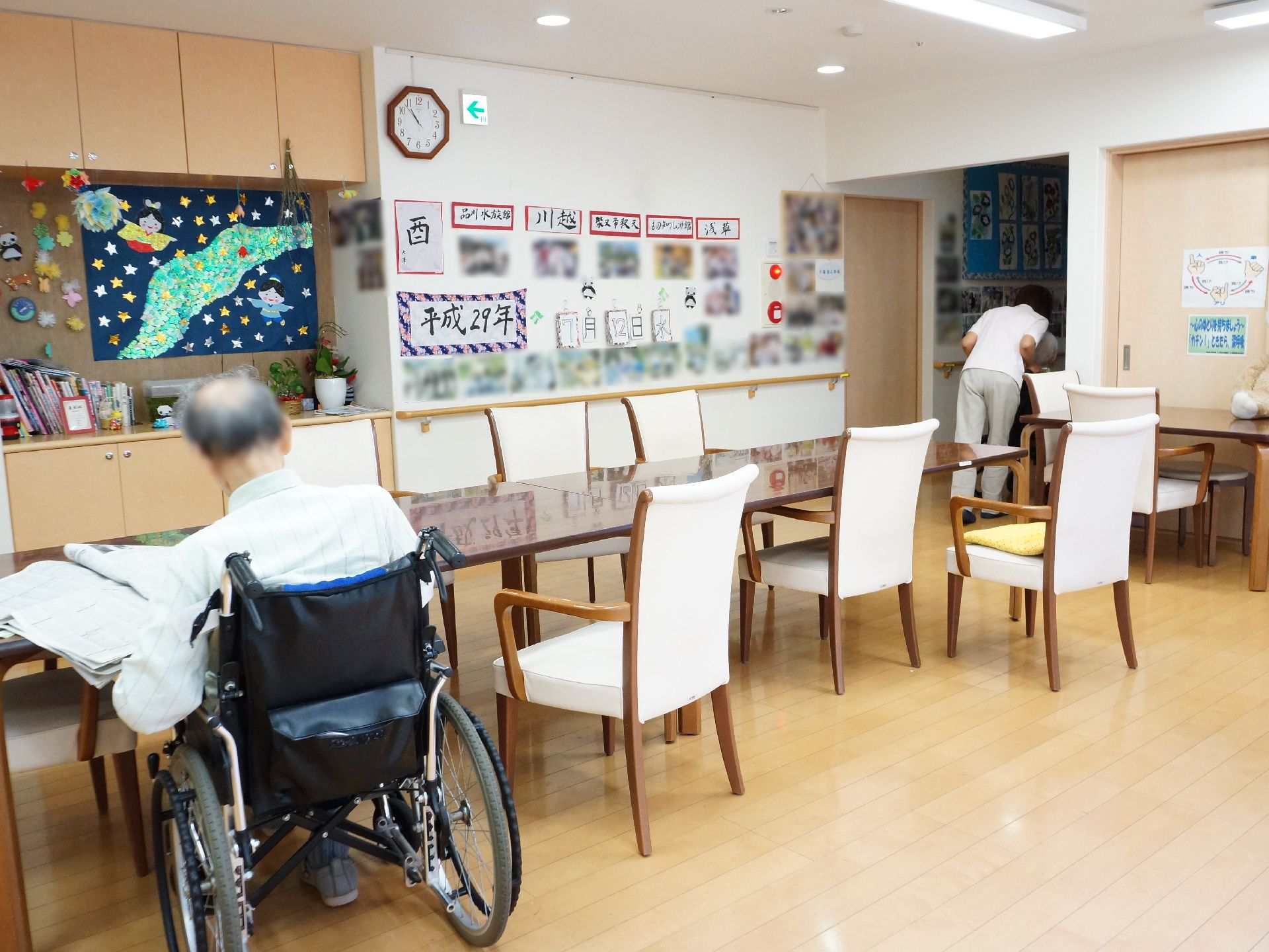リビングダイニングの壁手すりが設置されている。壁には沢山の写真や季節を感じられる手作りの掲示物がある。