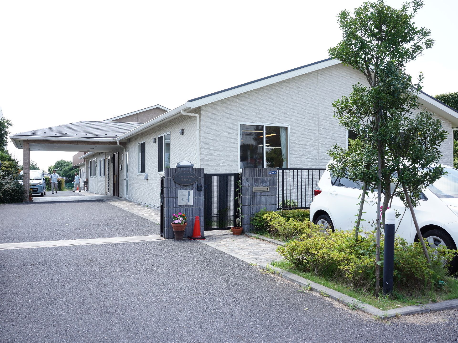 手前が駐車スペース。門を挟んで建物の敷地になっていて安全に配慮している。建物手前には、小規模多機能ホームが、奥の2階建てがグループホーム。