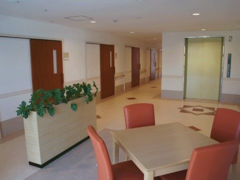 テーブルと椅子を配している、居住区へと続くエレベーターホール