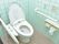 温水洗浄機能付き便座のトイレになっている。便座の両脇には手すりがついている。ナースコールも設置されている。