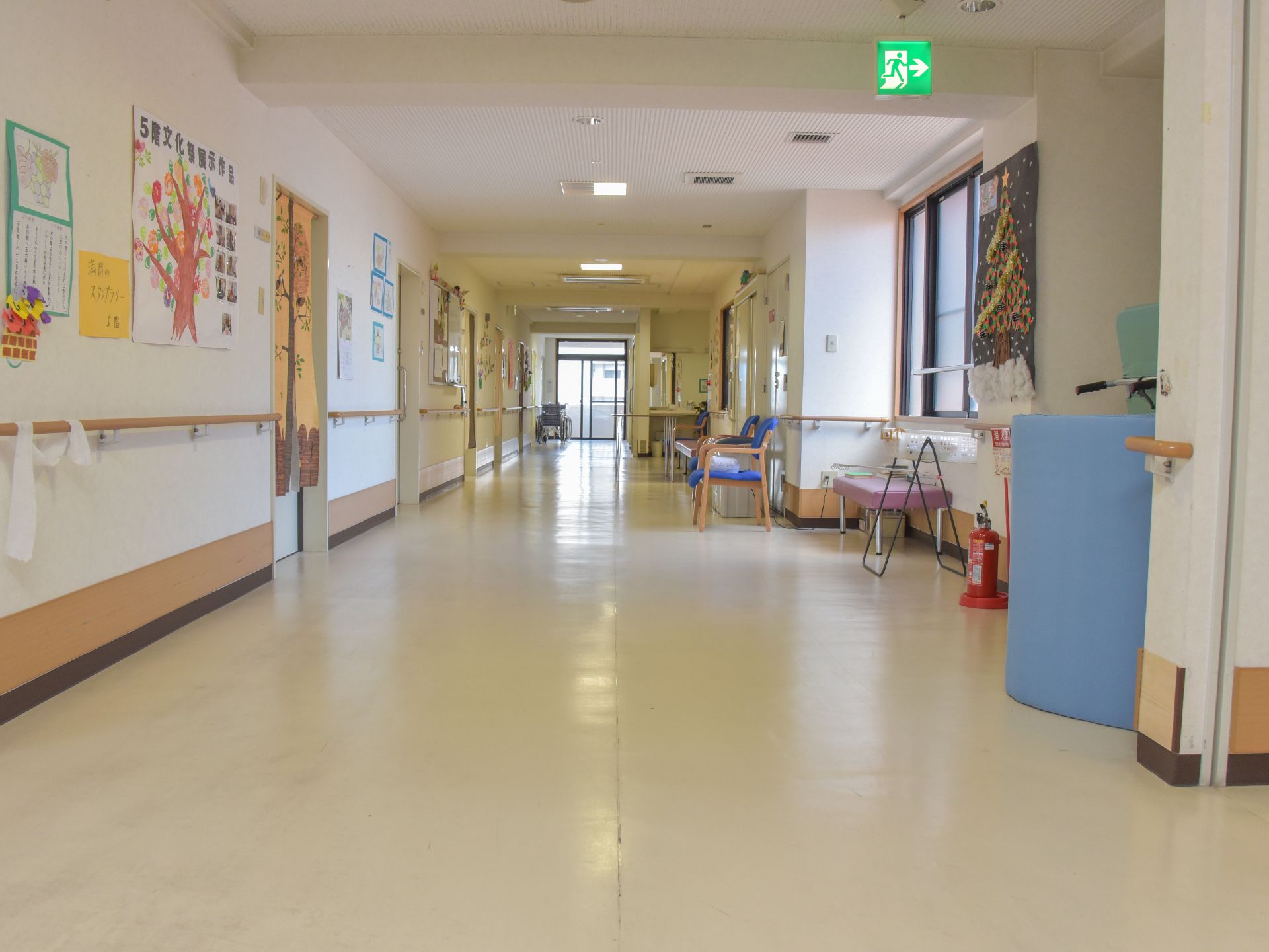 廊下は広くとられ、両脇には手すりが設置されている。居室が並ぶ反対側には窓がある。壁には絵や作品などが展示されている。