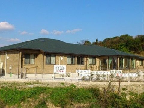 薄茶色の壁の平屋建ての施設である。施設の周りには緑が多く、フェンスで囲われている。駐車場も完備している。