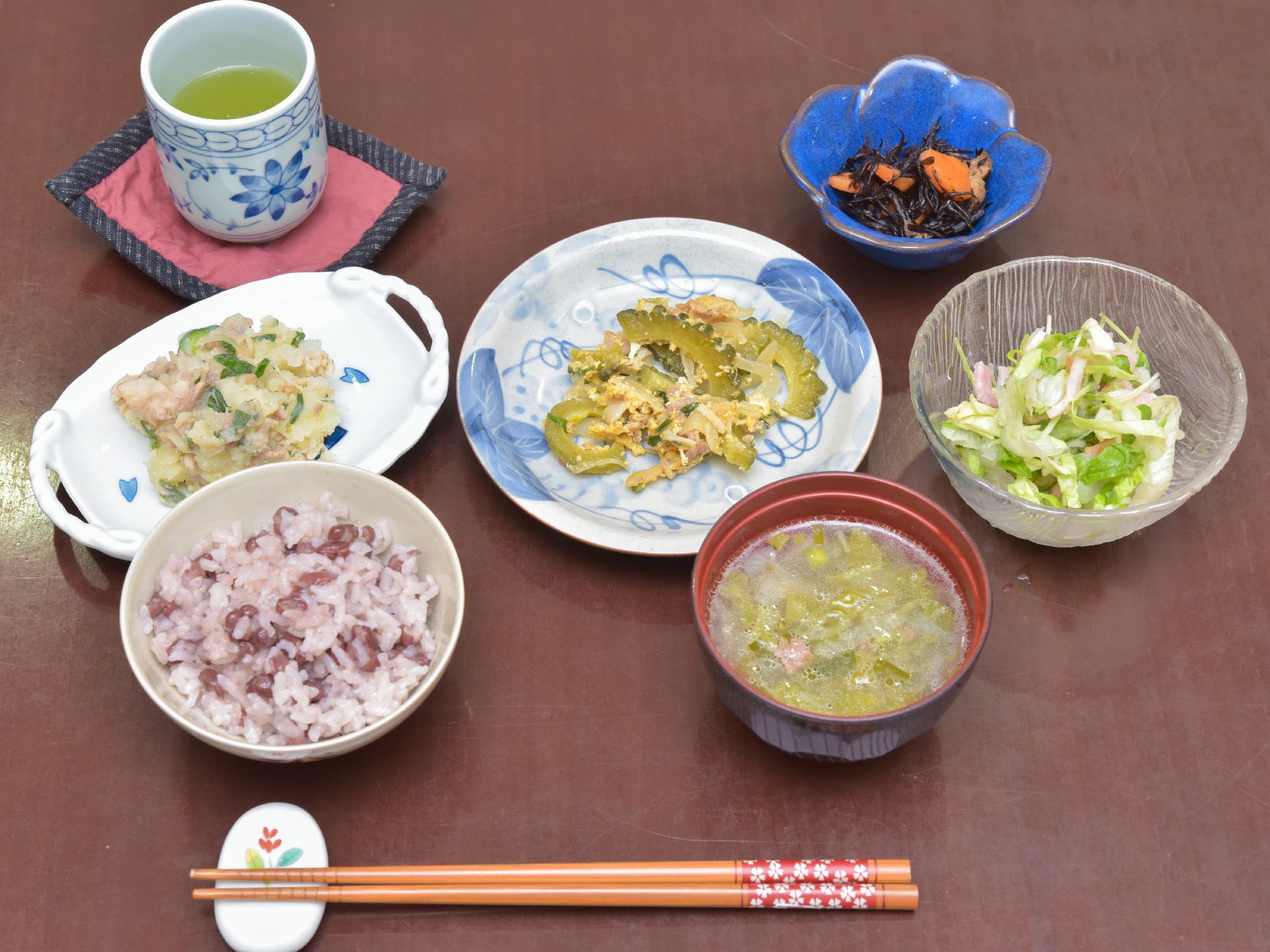 ご飯の内容は、ご飯、汁物、サラダ、おかず2品、小鉢がある。全体的に野菜が多い。お皿は陶器で提供されている。