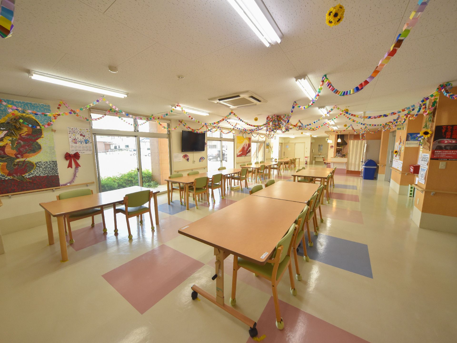 壁にテレビが取り付けてある食堂で、40名ほど収容ができる。椅子は緑色で、肘付きなため、立ち居が楽である。