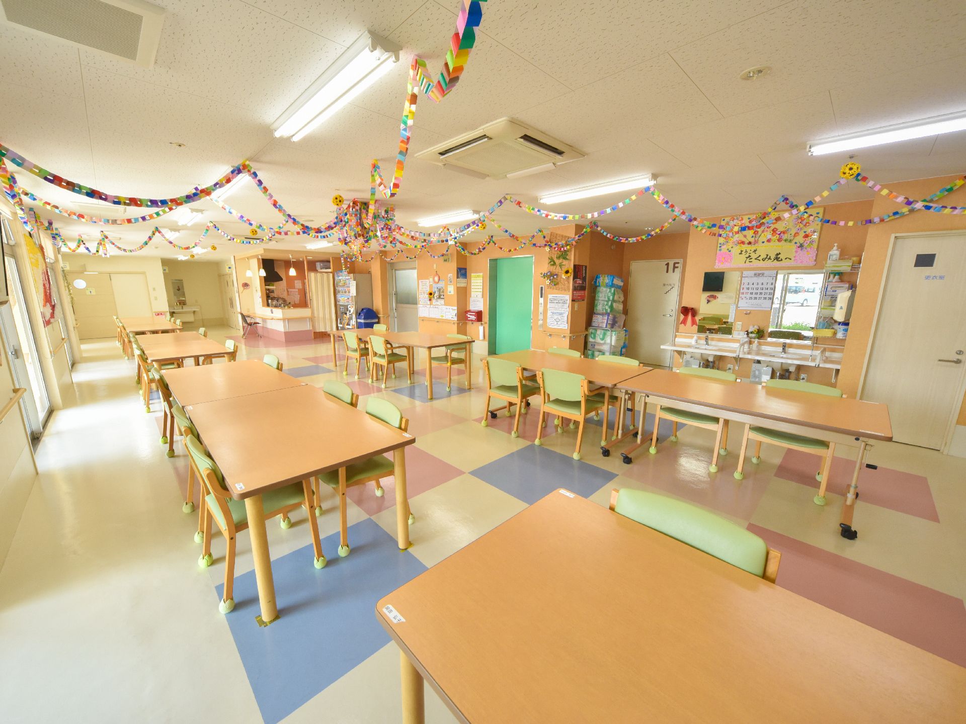天井から折り紙で作られたガーランドなどが飾ってある食堂で、洗面台が二台設置してある。自動販売機がある。