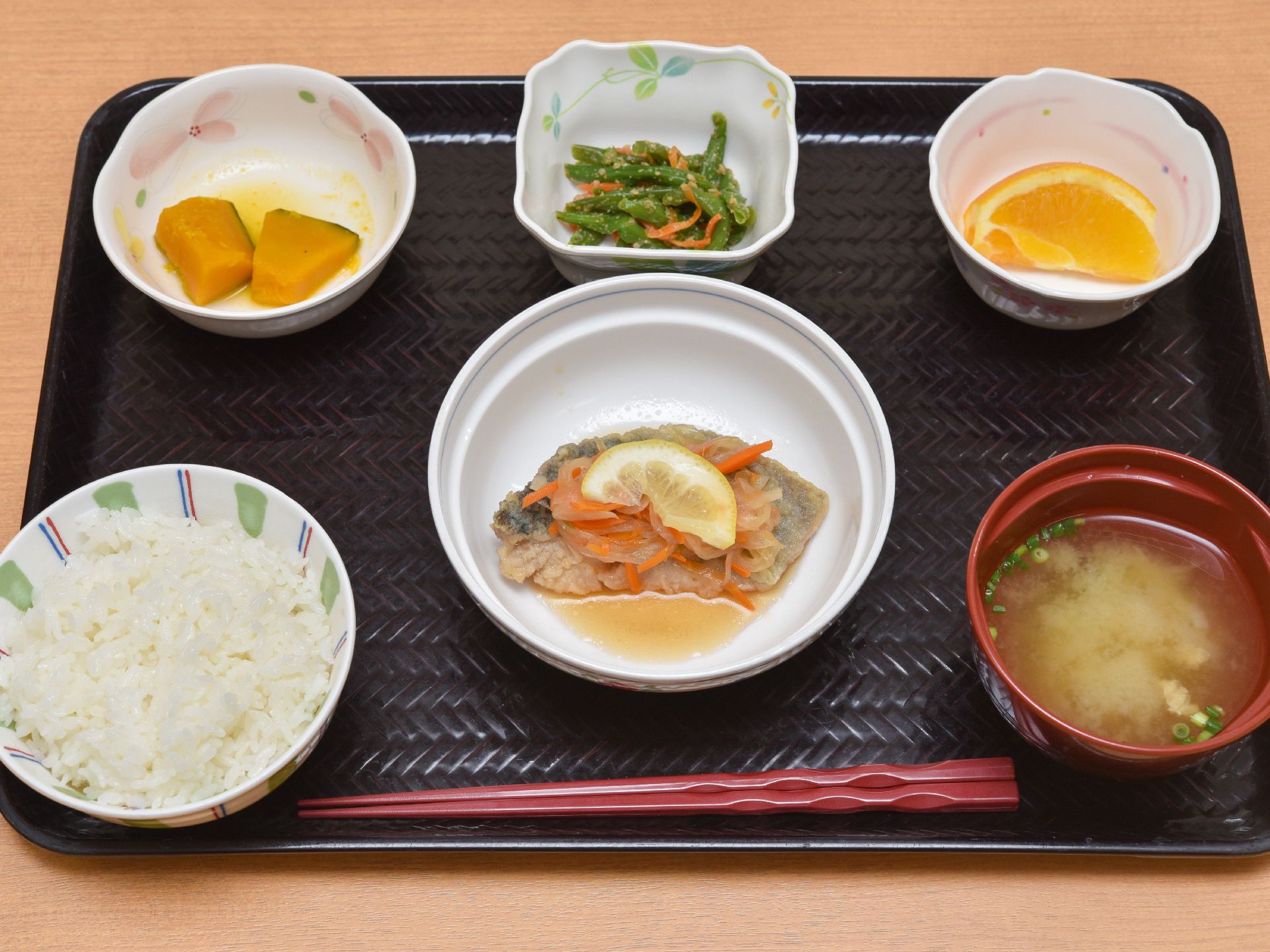黒いトレイに一膳赤い箸がおいてある。ごはん、味噌汁のほかに、鉢が三つほどのっていて、そのうちの一つはフルーツである。