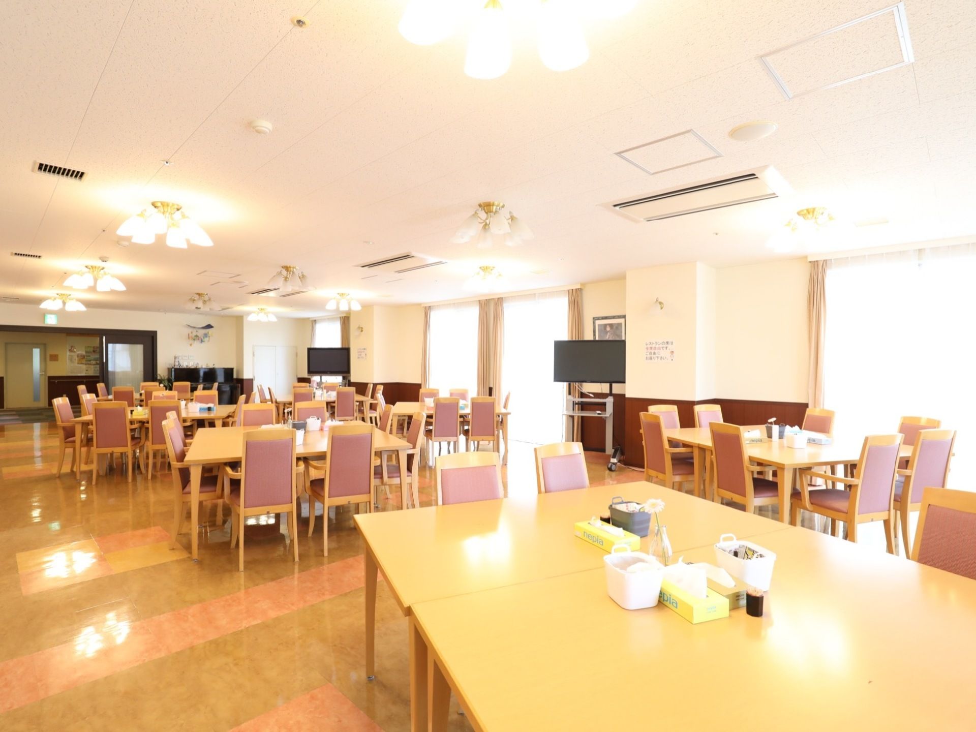 広々としたスペースに、テーブルと椅子が数多く設置されている。天井にはシャンデリア式のライトがついており明るい。