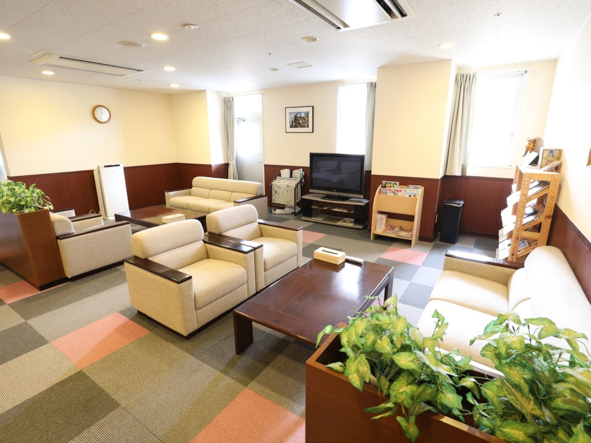 カラフルなじゅうたん敷きのスペースにソファーが数多く設置されている。テレビがあり、新聞や雑誌もラックに置いてある。