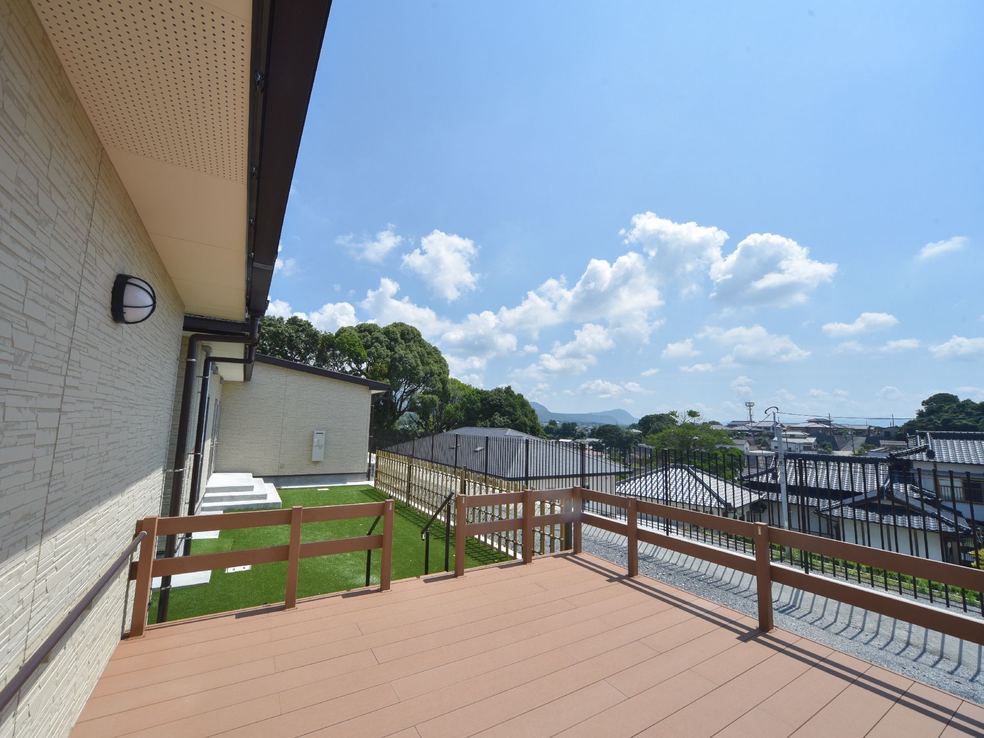 周囲に高い建物がなく、遠くの山まで見える、日当りのよいウッドデッキ