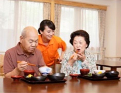和食のご飯を楽しむご夫婦のご入居者様と食事の様子を伺う職員