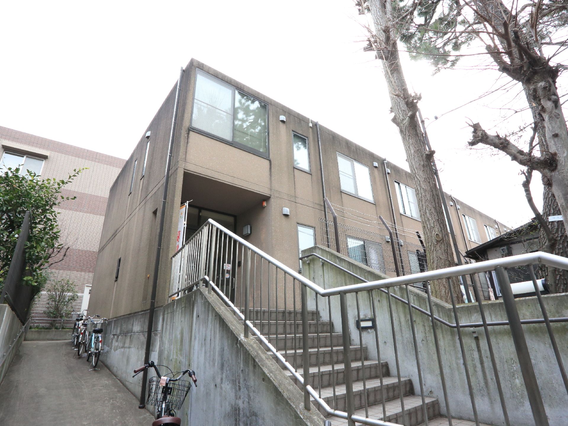 入口に通じる階段には手すりが設置されている。スロープは施設の裏側まで長く続いているので、車いすの方も利用できる。