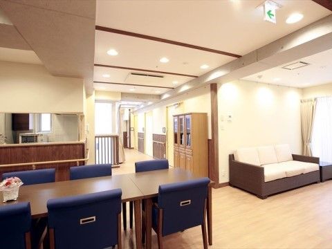ソラスト台東のリビング。ダイニングセットとテレビが配置されている。
