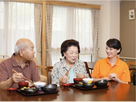 ご夫婦のご入居者様のお食事中に、楽しい話題を話す職員