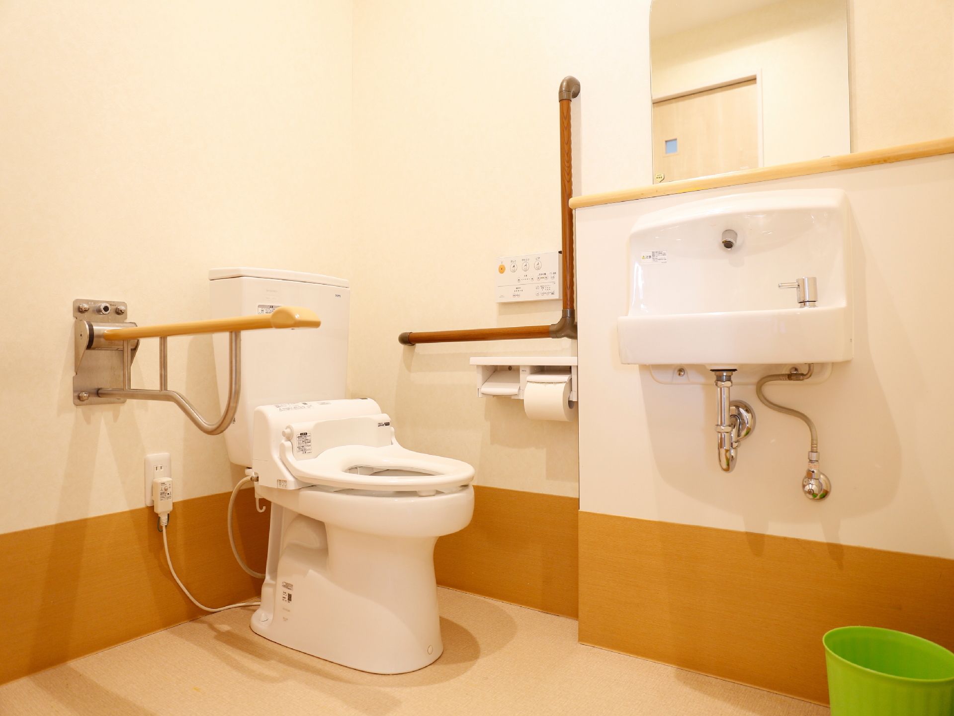 トイレはフラットな床なので、車椅子の方に配慮したつくりになっている。手すりが設置されているので座る時に安全である。