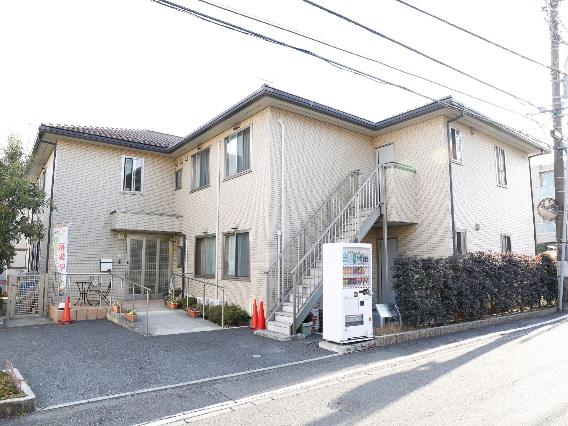 エントランス前には車を一時停車するスペースあり。エントランスまでは緩やかなスロープになっていて入口はスライドドアなので大きく開放できる。