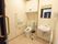 広いスペースのトイレがある。上部には棚があり、壁には手すりが設置されている。洗面台と鏡があり、横には手すりがある。