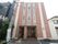 ３階建て施設の外壁は、やさしい色のコントラストが印象的である。入口前まで点字ブロックが設置されているのが見える。