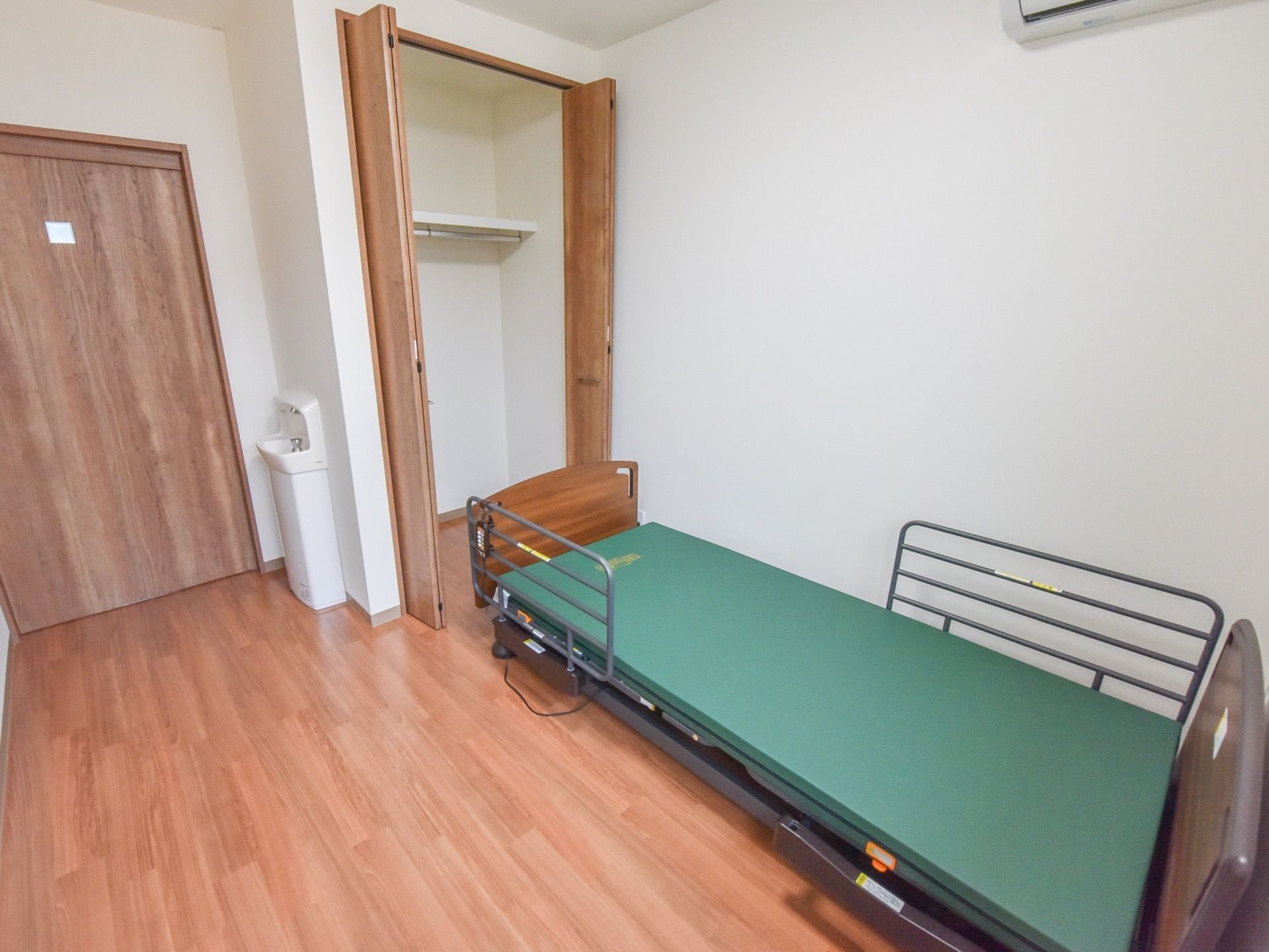 個室の居室なので、入居者様はのびのびと生活することができる。ベッドやエアコンはもちろん、洗面所も設けてある。