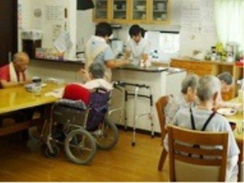 多種の食器が並ぶ食器棚があるキッチンと広いテーブルが置かれた食堂