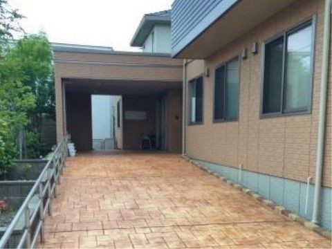建物の色にマッチしたあたたかい色のエントランスは、全面が緩いスロープになっている。脇に草花が植えられ、来訪者様を温かく迎える。