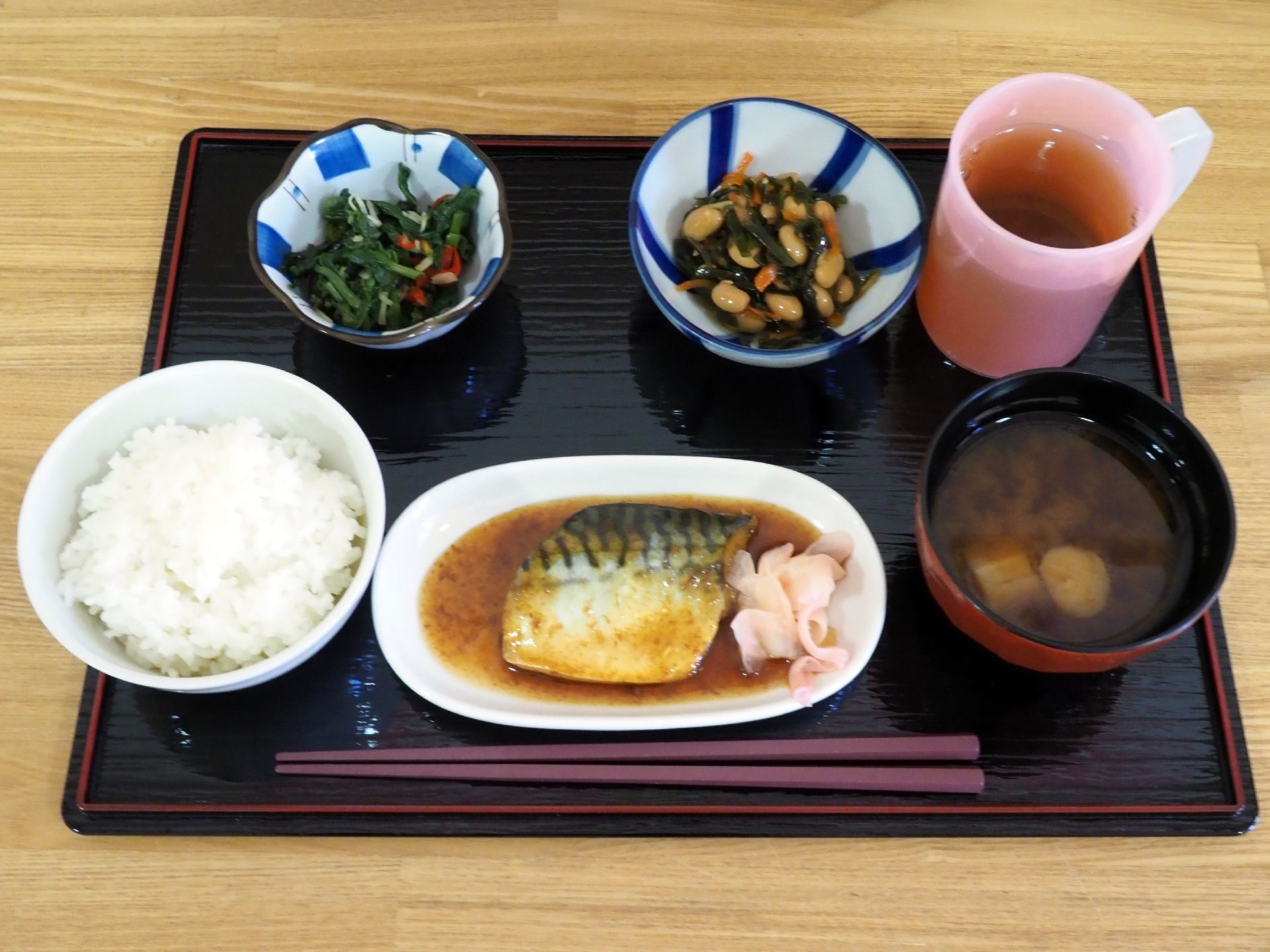 野菜を多く使った、ご飯と味噌汁の和食セット。豆の煮物や魚料理が並んでいる。