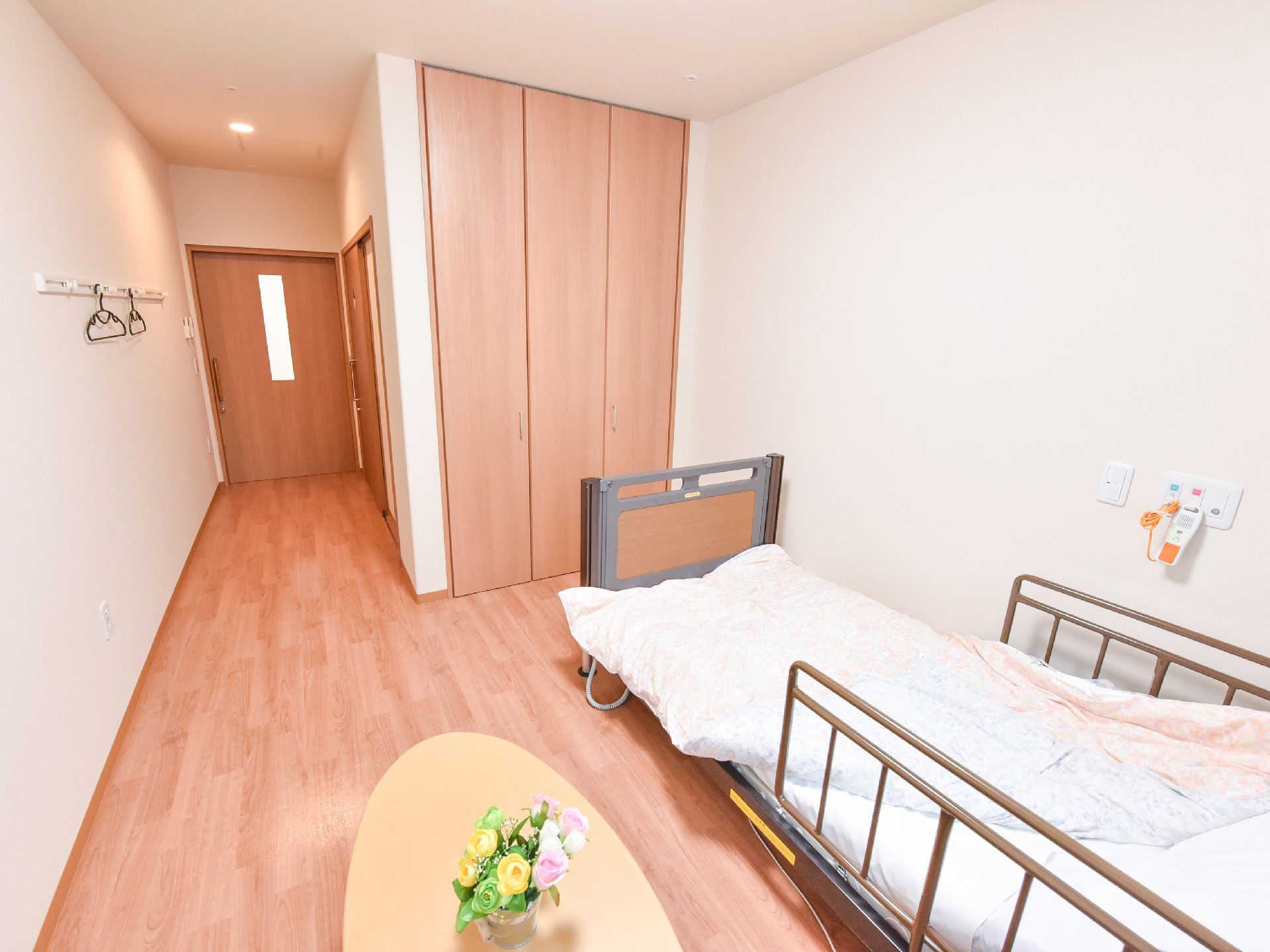 個室の入り口は小窓が設けられた木製の引き戸である。壁には複数のフックがあり、ハンガーが掛けられている。ベッドが置かれている。