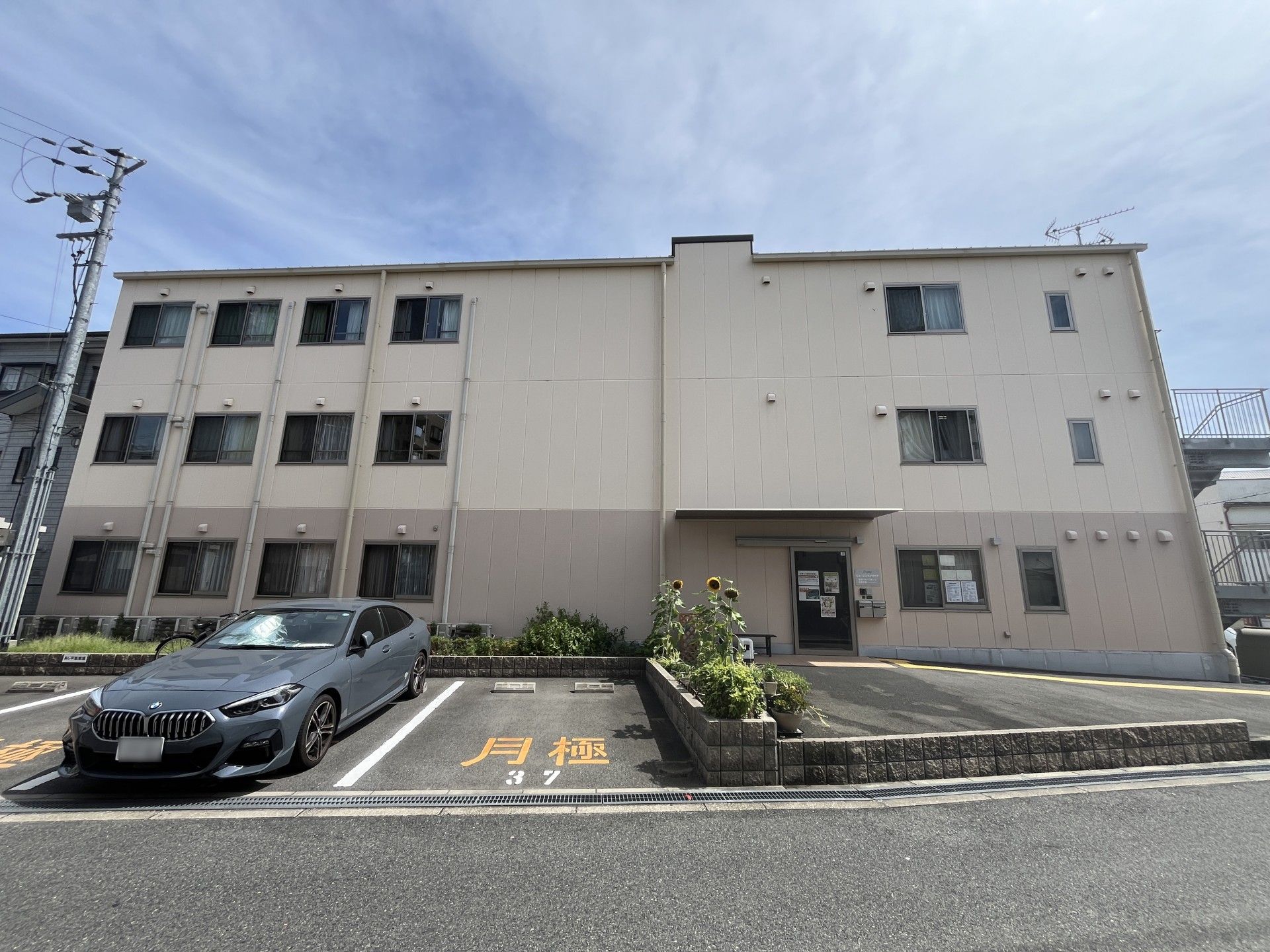 階段に大きな当施設のタペストリーがかけられた、3階建ての建物