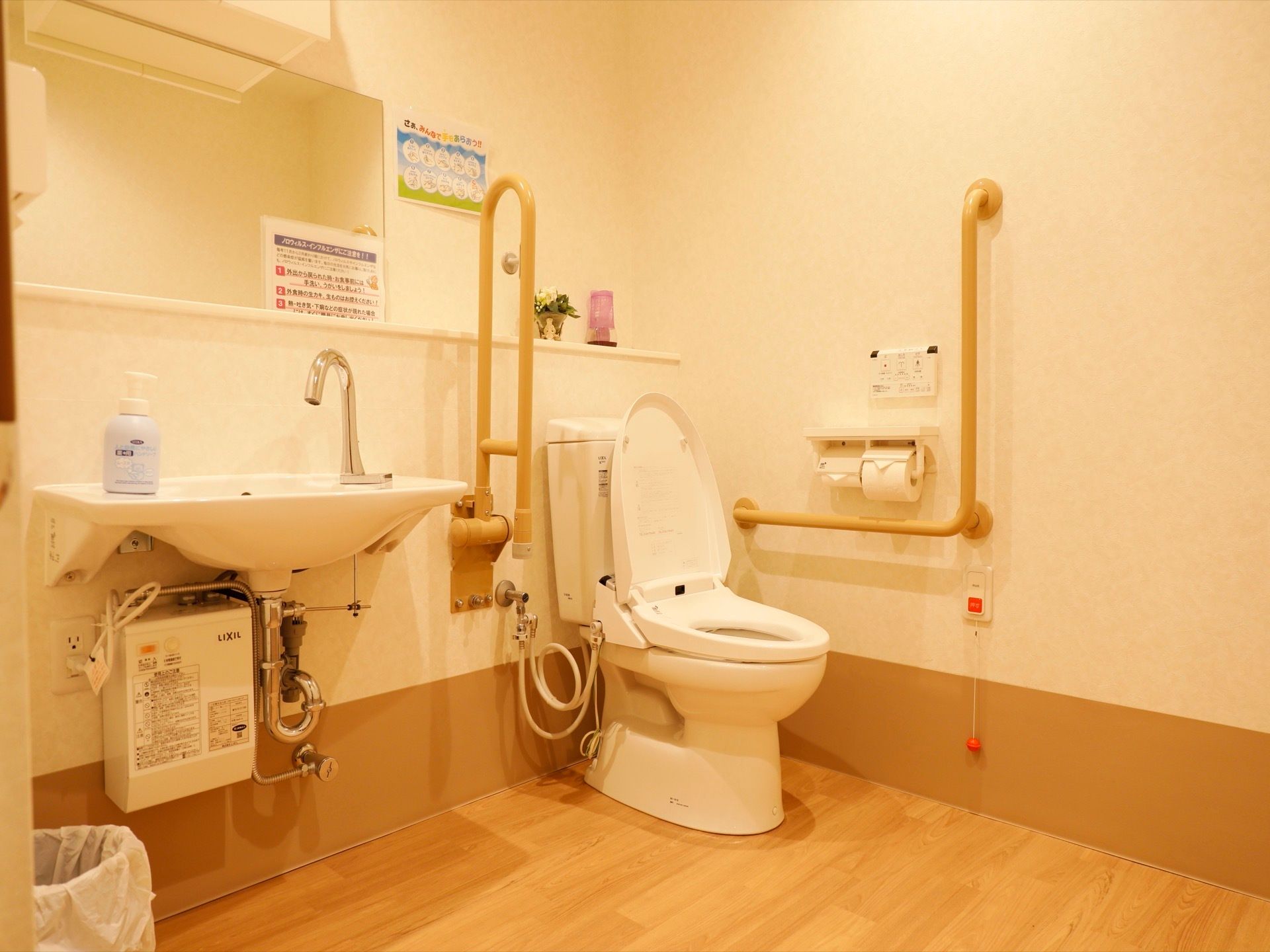 トイレの個室内は便器の隣に洗面台が設けられたスペースに余裕を持った設計で、手すりや緊急時呼び出しベルが備わっている。