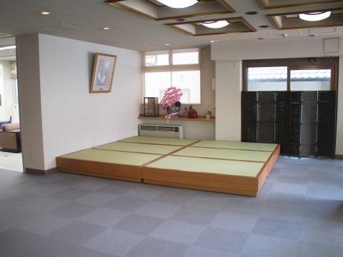 広い空間が仕切られ、手前は置き畳で奥はソファを設置