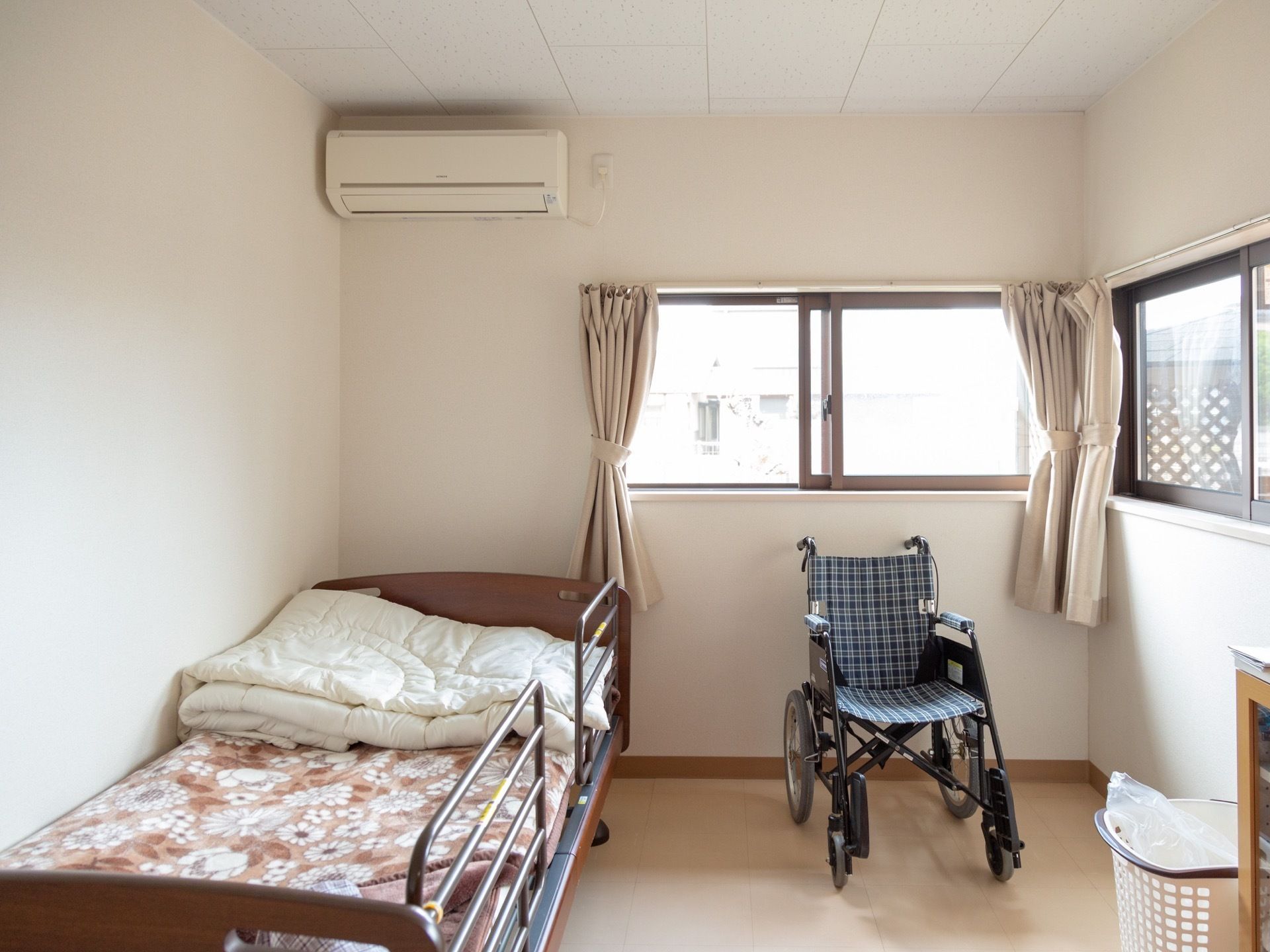 壁が白く、清潔感のある明るい居室である。エアコンが設置されており、１年を通して快適に過ごすことができる。